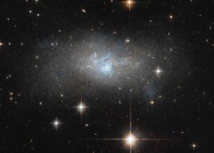 Hubble Space Telescope – Distant Galaxy With Bright Blue Cosmic Gas Filaments