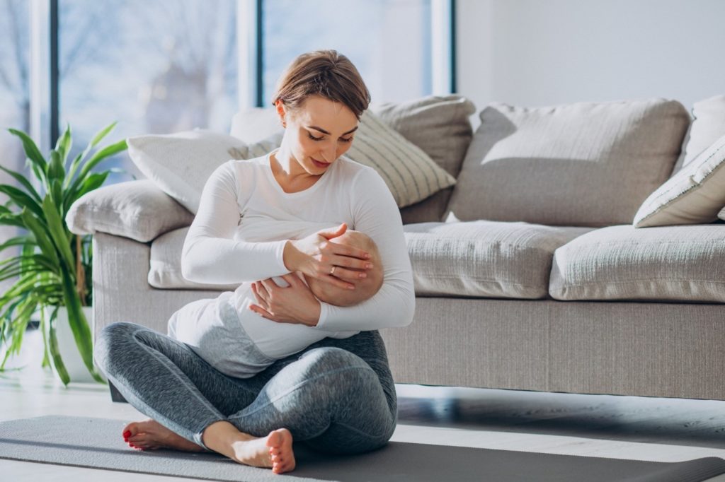 Woman sitting on the floor breastfeeding her baby